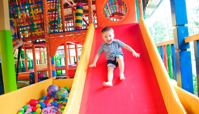 Child on a slide at an activity warehouse